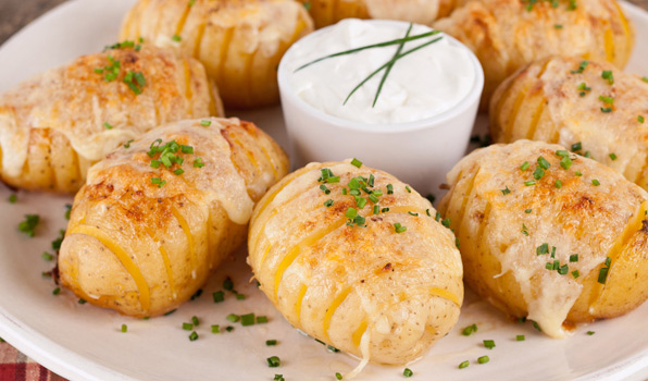 in the kitchen with stefano faita cheesy fan potatoes with chopped chives as garnish and sour cream for dipping