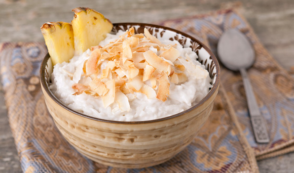 in the kitchen with stefano faita coconut rice pudding in a bowl garnished with coconut shavings and pineapple slice