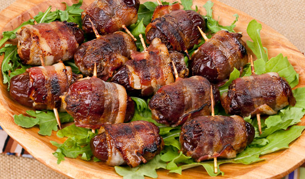 in the kitchen with stefano faita devils on horseback with arugula leaves on a wooden dish