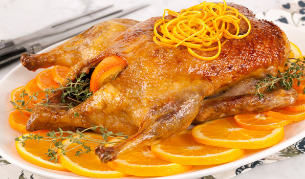 in the kitchen with stefano faita stefano's duck a l'orange on a platter garnished with orange slices, blanched orange zest and thyme sprigs and served with orange sauce