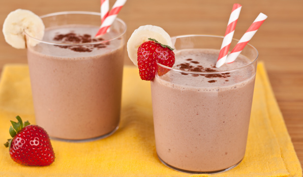 in the kitchen with stefano faita funky monkey milkshake served in two glasses with strawberries and bananas as garnish and two candy cane straw in each