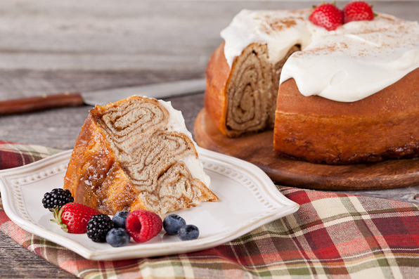 in the kitchen with stefano faita giant cinammon bun slice with cream cheese icing on a plate with mixed berries