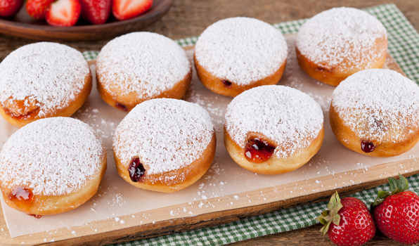 in the kitchen with stefano faita jelly donuts served on a wooden board with strawberries on the side