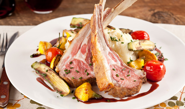 in the kitchen with stefano faita lamb chops with red wine reduction, garnished with chopped chives and served on a plate with a side of mashed potatoes and sautéed vegetables