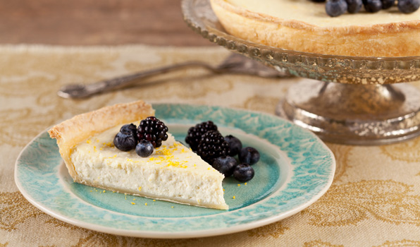 in the kitchen with stefano faita lemony ricotta pie slice on a plate with lemon zest, blueberries and raspberries on top