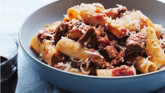 gino's italian escape rigatoni with wild boar ragu served in bowl and topped with shredded parmesan cheese