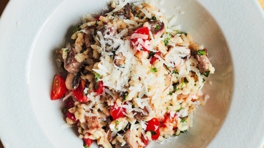 gino's italian escape duck risotto with mushrooms and cherry tomatoes with cheese sprinkled over