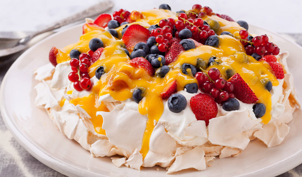 in the kitchen with stefano faita pavlova with berries and mango coulis served on a large white dish