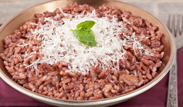 in the kitchen with stefano faita red wine risotto in a bowl, garnished with grated parmesan cheese and basil leaves