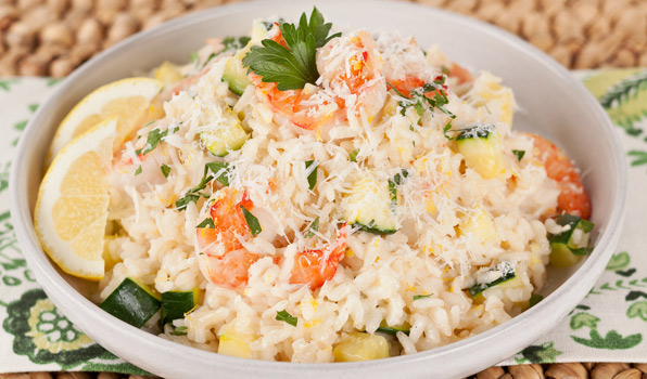 in the kitchen with stefano faita shrimp and zucchini risotto served with grated parmesan cheese and garnished with lemons and parsley