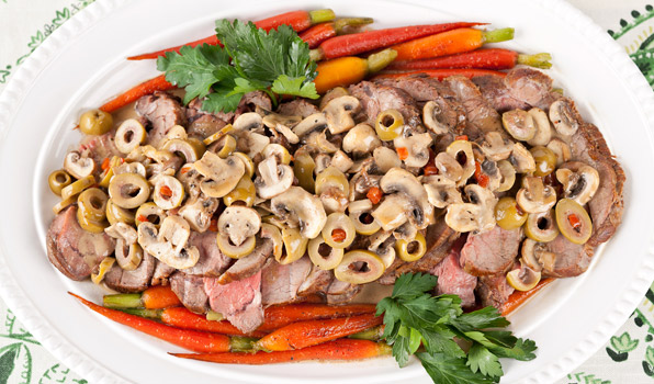 in the kitchen with stefano faita veal roast with mushrooms and olives served on a platter with honey glazed baby carrots